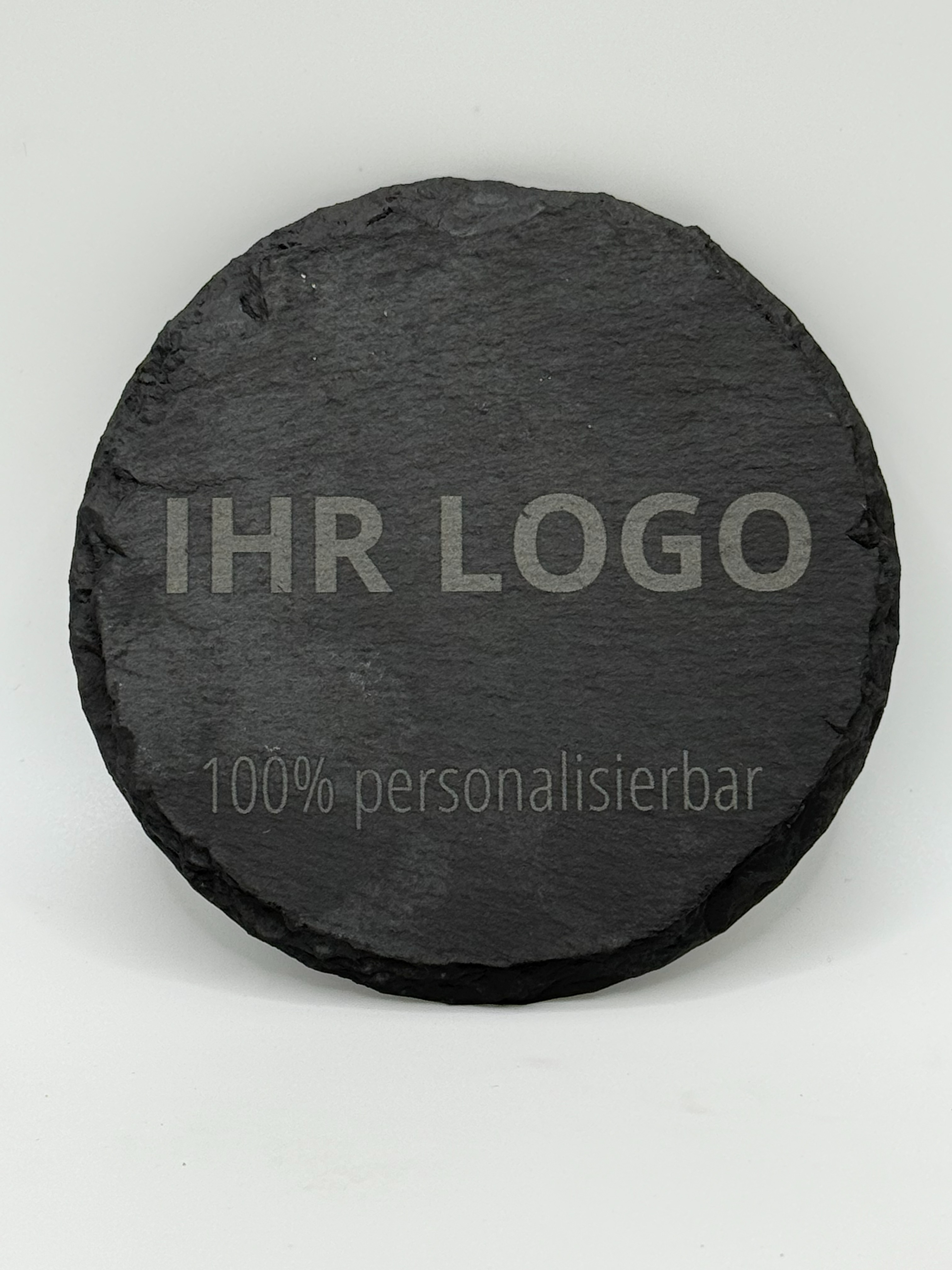 Runder Schieferuntersetzer mit 10 cm Durchmesser aus dunklem Naturschiefer mit heller Lasergravur "Ihr Logo - 100% personalisierbar"